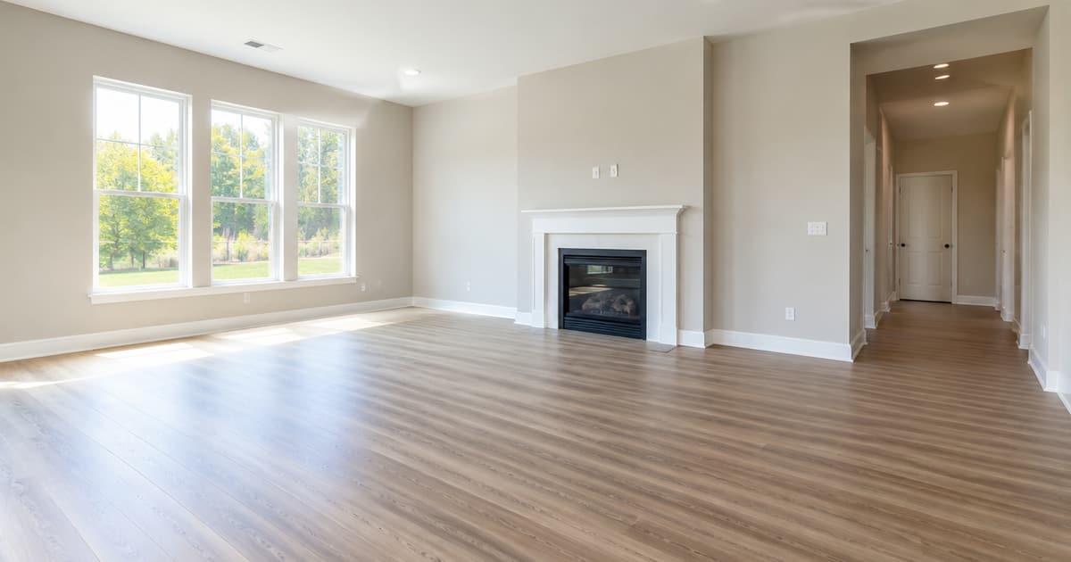 A newly finished neutral living room with fresh paint and new flooring
